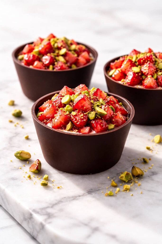 Dubai chocolate strawberry cup with dark chocolate shell, fresh strawberries and pistachios