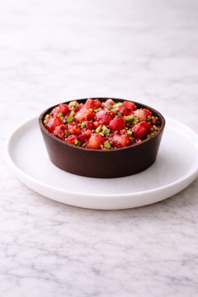 Elegant Dubai chocolate strawberry cup served on light marble surface
