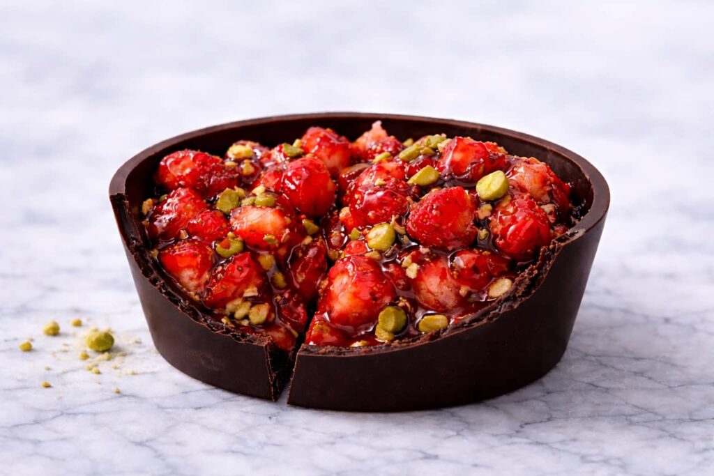 Halved Dubai chocolate strawberry cup showing crisp chocolate shell and juicy strawberry filling