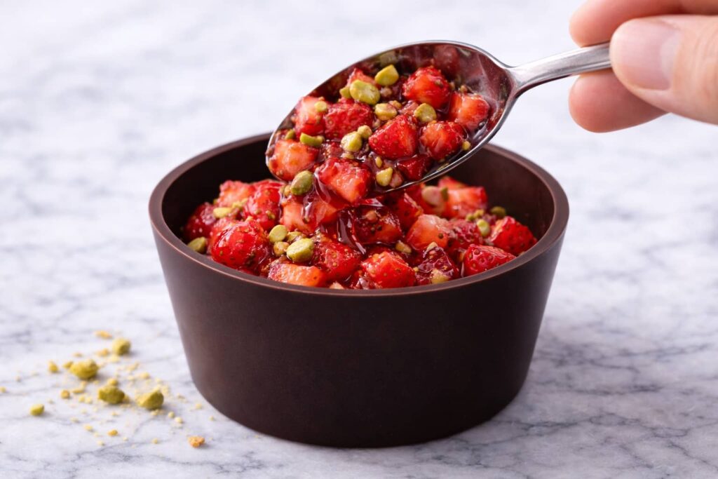 Spreading melted chocolate in molds to create double-layer chocolate shells