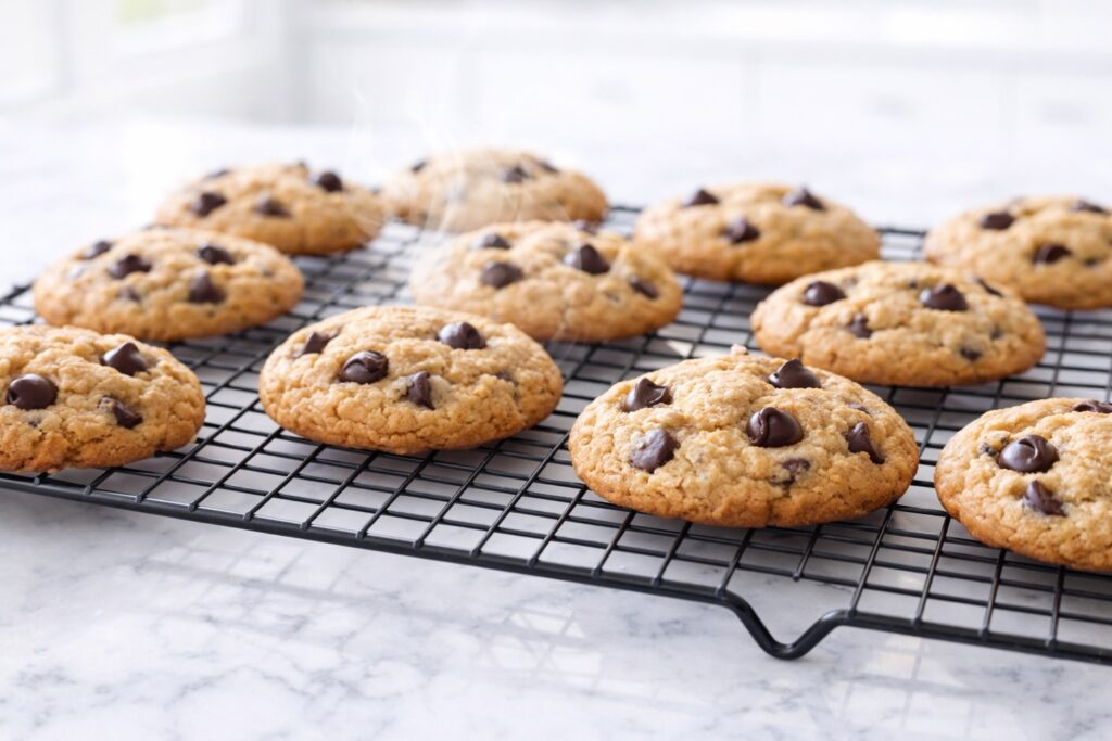 Peanut butter chocolate chip cookies cooling on a rack after baking