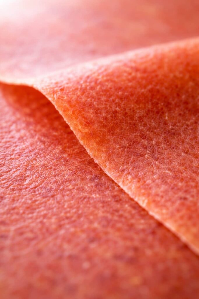 Fruit Roll Ups Texture Close-Up (Fruit Leather) close up of homemade fruit roll ups texture showing thin flexible fruit leather surface