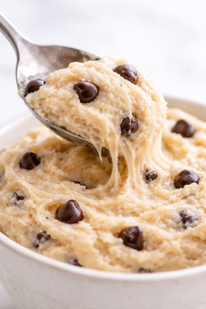 spoon scooping edible cookie dough showing creamy soft texture and chocolate chips