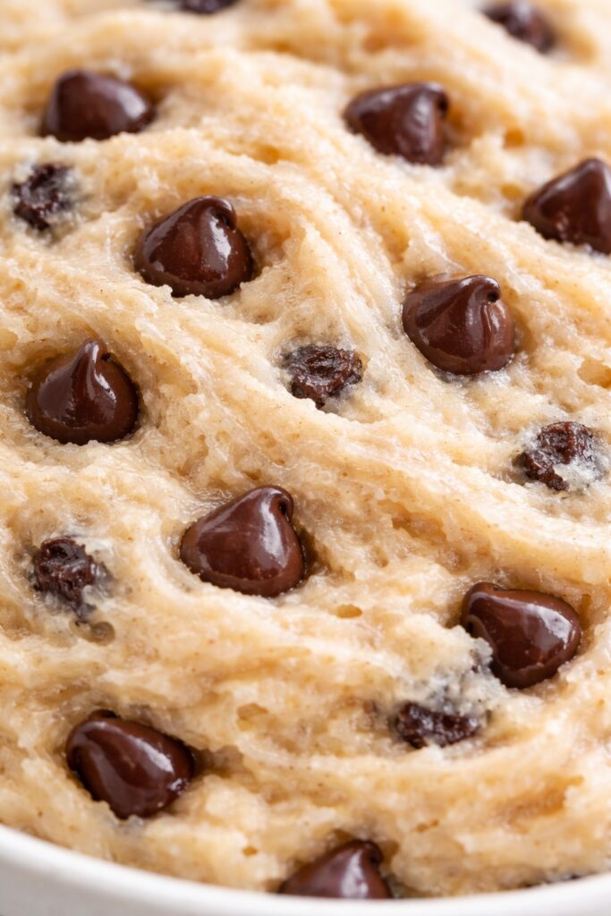 extreme close-up of edible cookie dough showing dense creamy texture with chocolate chips