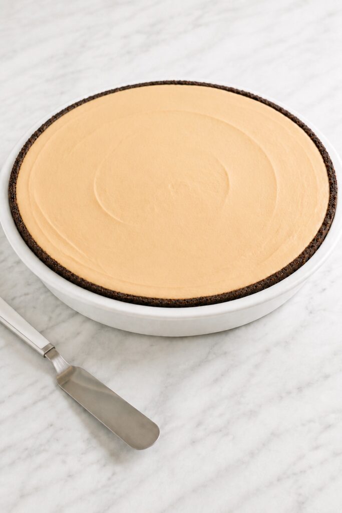 Peanut Butter Pie filled with smooth mousse and a slight center crown before chilling.