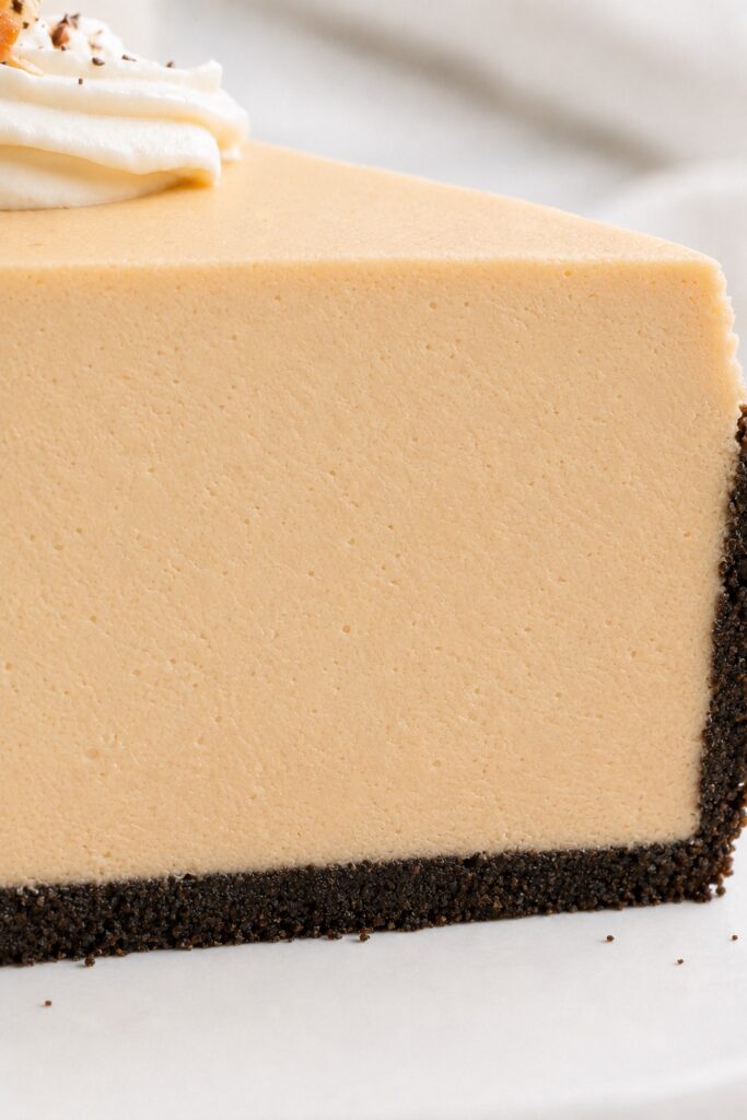 Close-up of the creamy peanut butter mousse, tiny air pockets, and crisp Oreo crust in a sliced pie.
