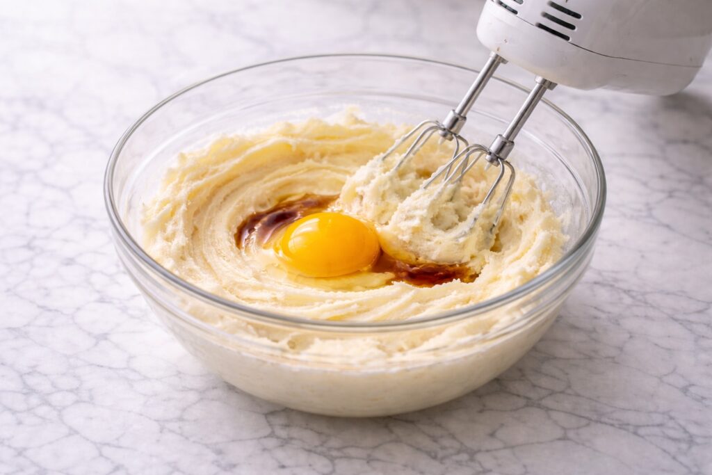 Egg and vanilla added to creamed butter and sugar mixture.