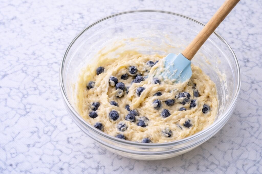 folding blueberries into muffin batter