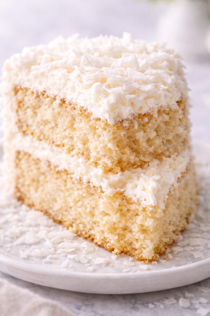 Close-up of coconut cake slice showing fluffy moist crumb texture.