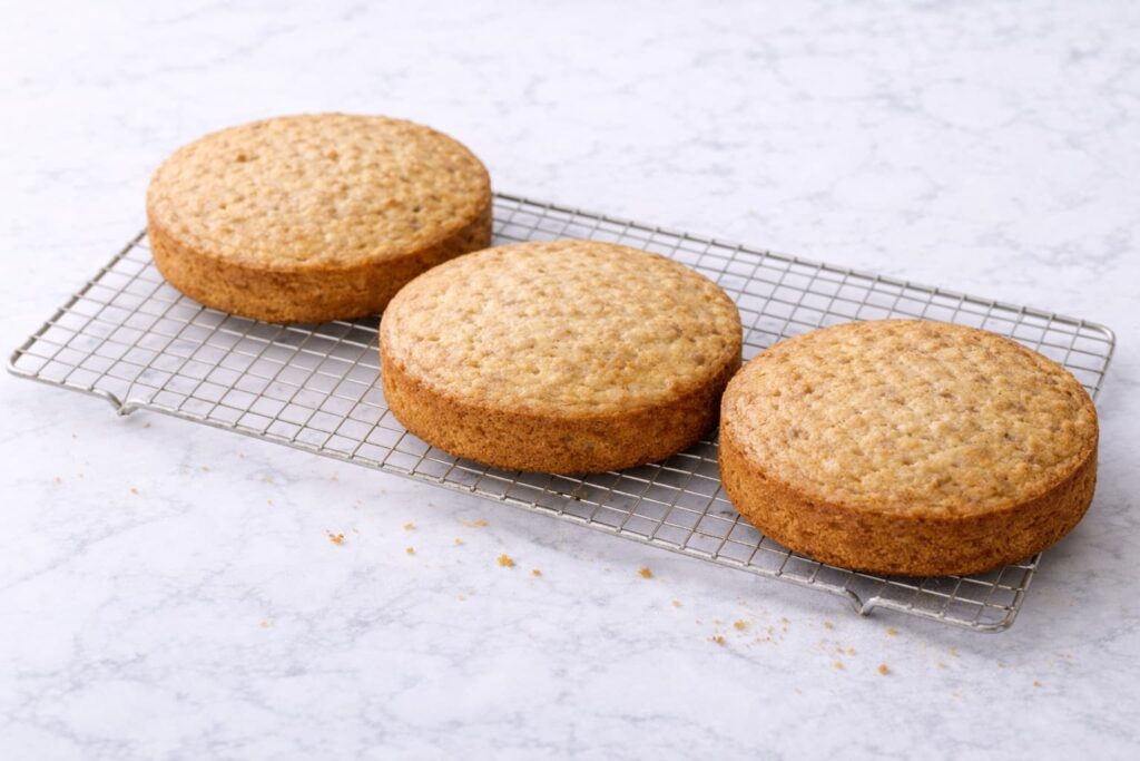 Hummingbird Cake Layers Cooling on Rack Hummingbird cake layers cooling on a rack with golden tops and natural crumb texture