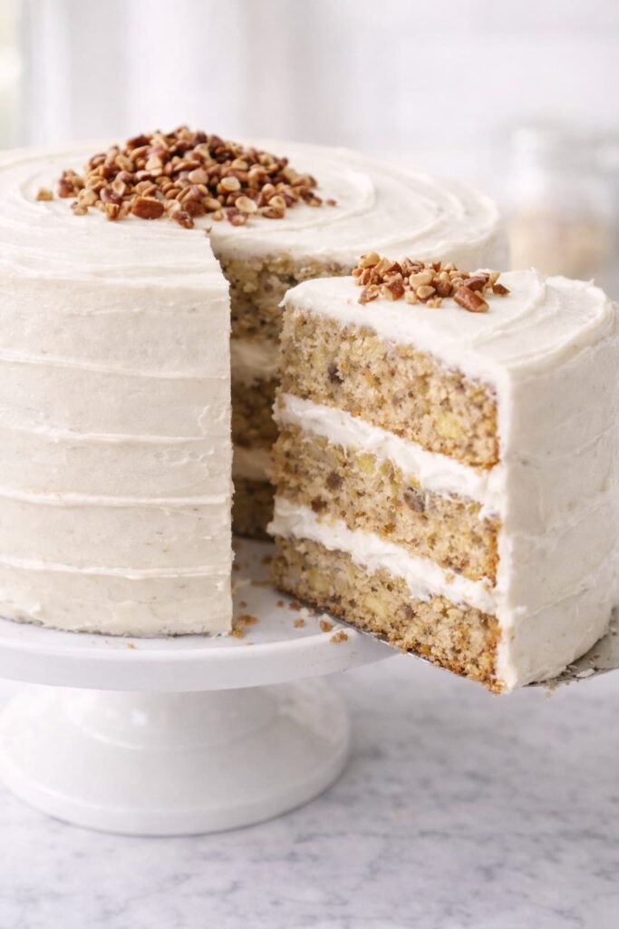 Hummingbird Cake Slice with Cream Cheese Frosting Moist hummingbird cake slice with banana pineapple layers and cream cheese frosting