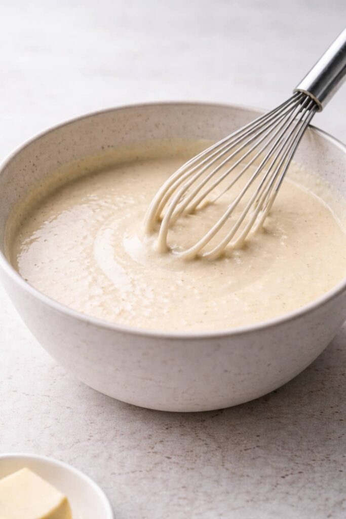 Sourdough discard pancake batter whisked until smooth in ceramic bowl