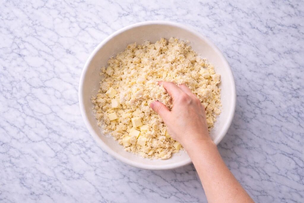 mixing butter and flour to make homemade apple pie crust dough