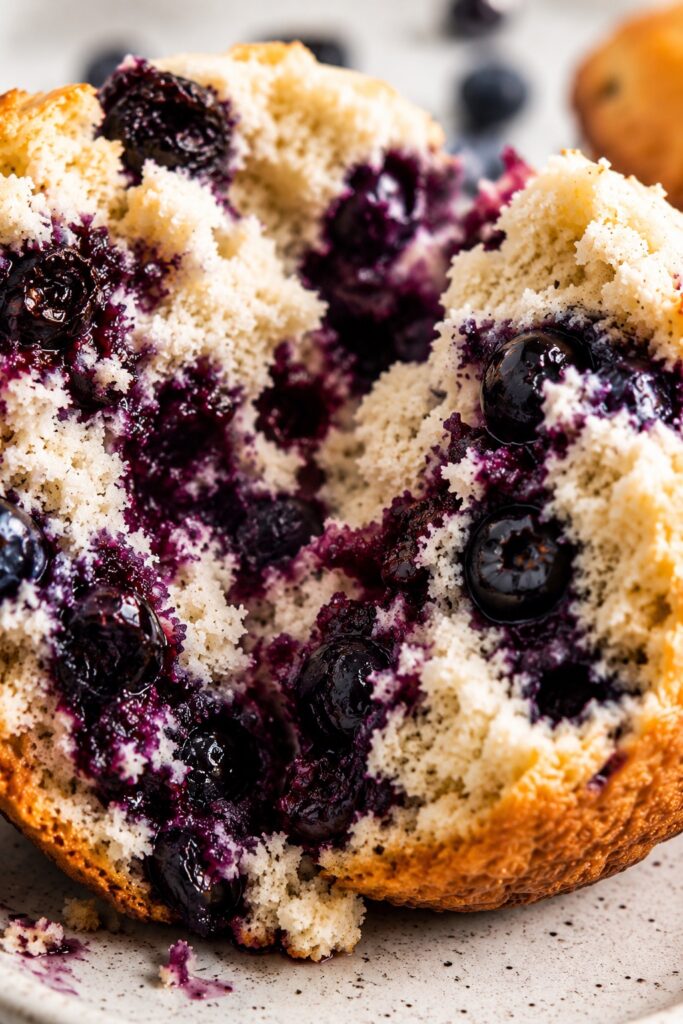 Close-up of moist healthy blueberry muffin crumb with visible whole blueberries and soft texture
