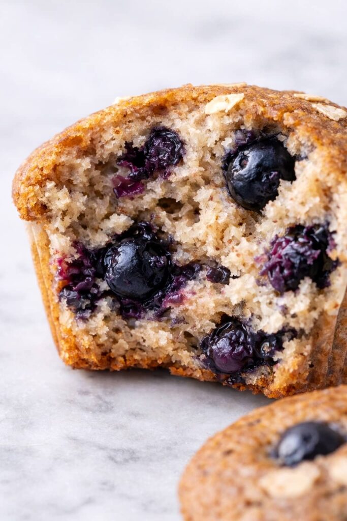 Close-up of moist healthy blueberry muffin crumb with visible whole blueberries and soft texture