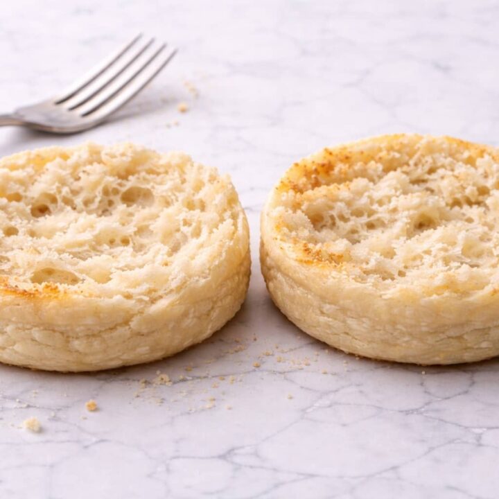 Homemade sourdough English muffins with airy nooks and melted butter