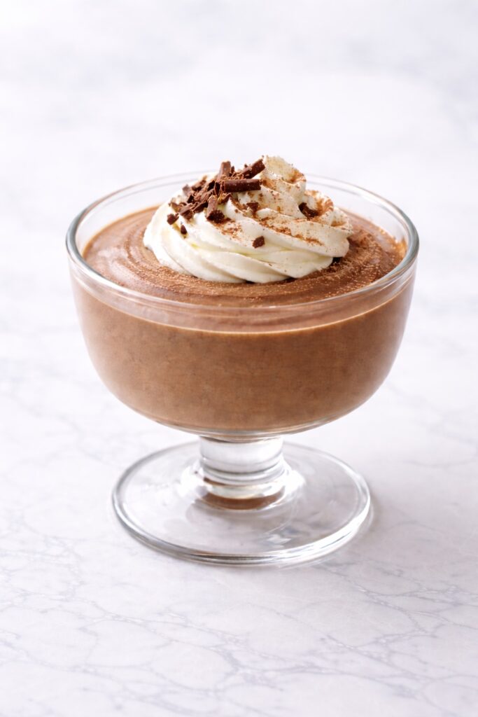 chocolate mousse with whipped cream and chocolate shavings elegant clean presentation