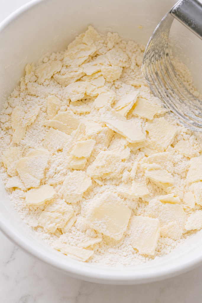 Irregular cold butter flakes coated in flour for flaky all-butter pie dough.