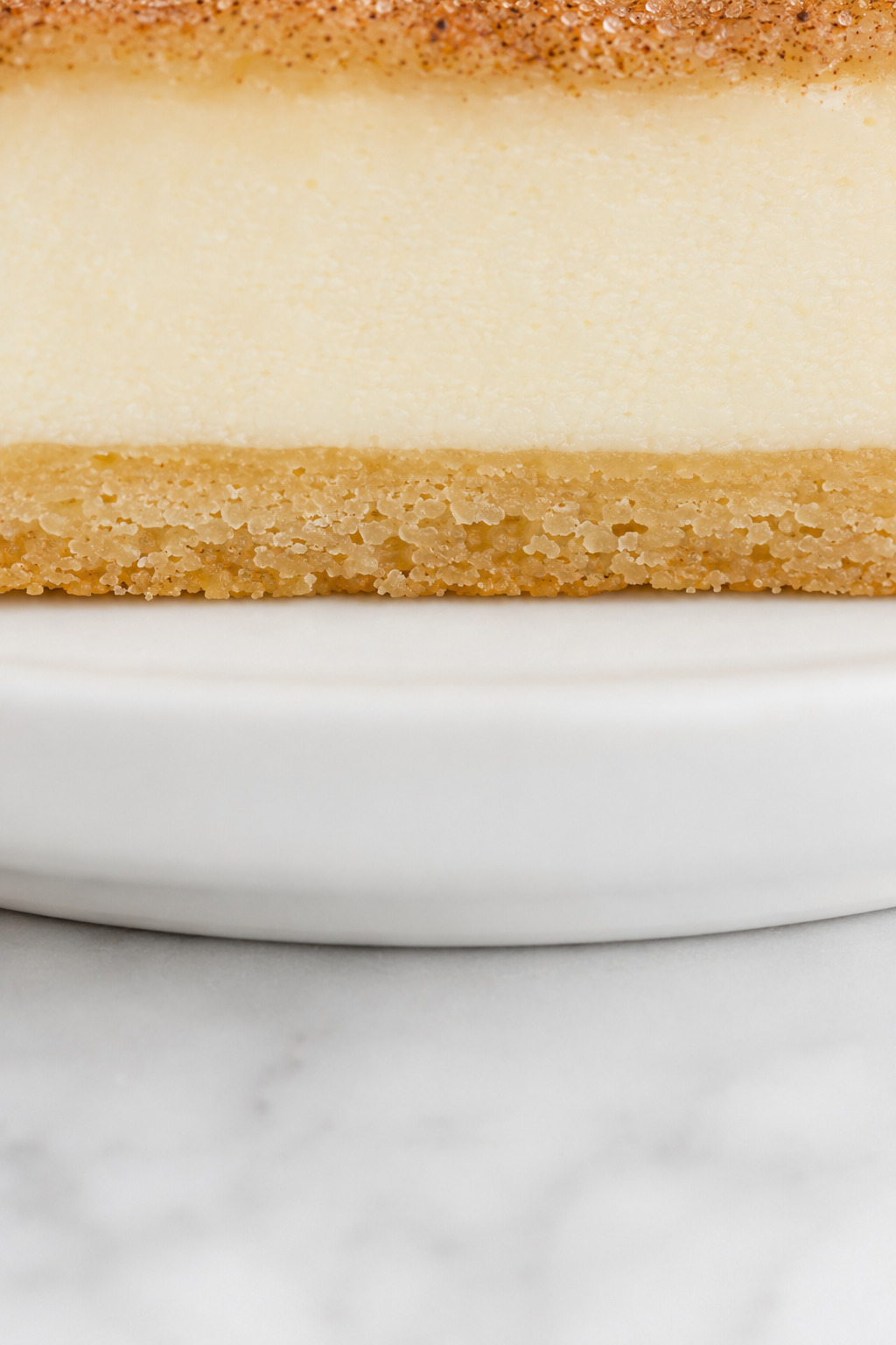 Close-up of the thin light-golden bottom crust and smooth cheesecake center in a Sopapilla Cheesecake bar.