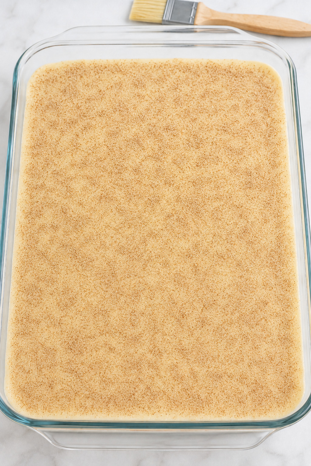 Unbaked Sopapilla Cheesecake with even cinnamon-sugar coverage and a thin butter sheen.