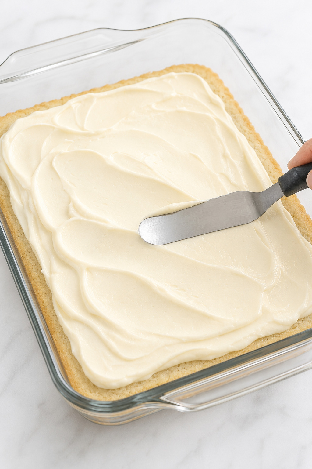 Cream cheese filling spread evenly over the par-baked crescent dough layer.