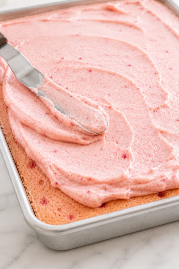 Spreading Strawberry Cream Cheese Frosting on Cake