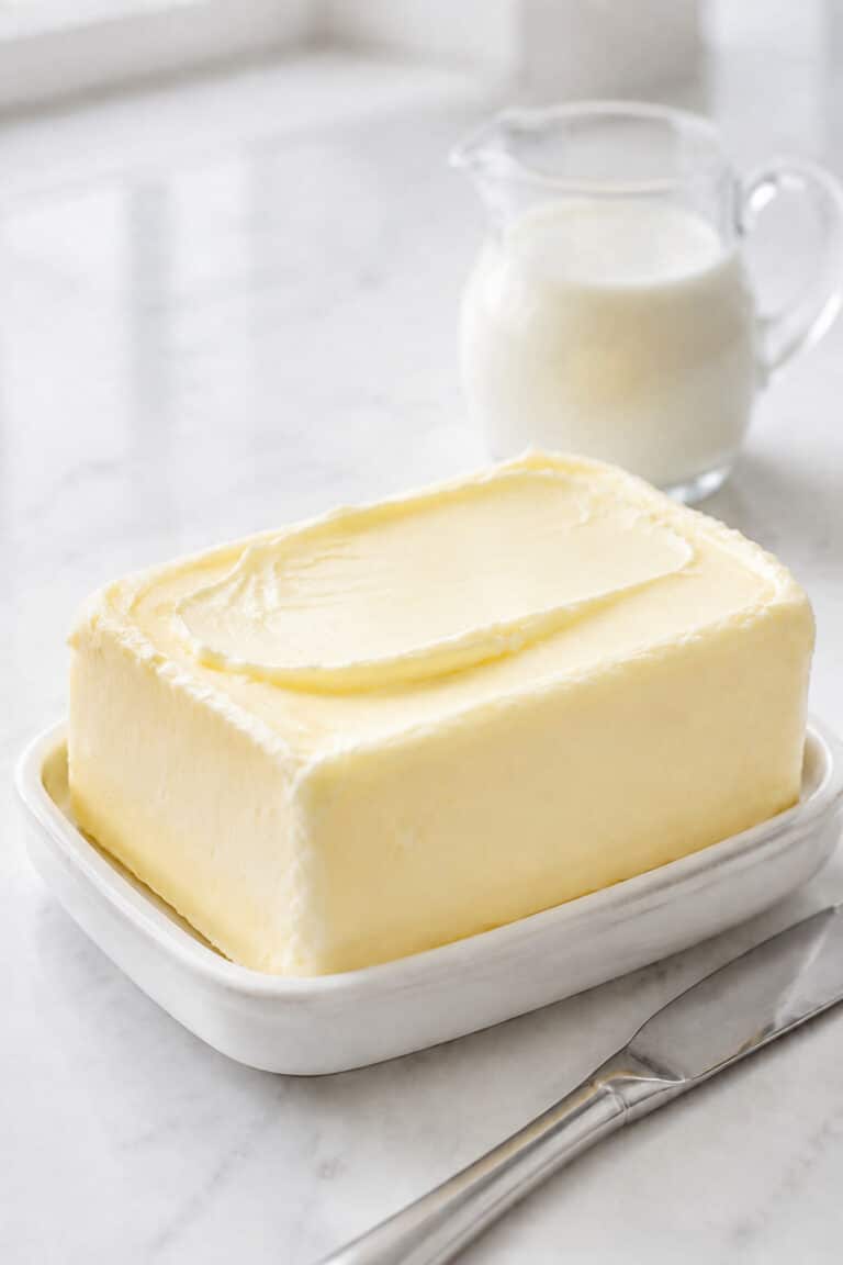Fresh pale homemade butter made from heavy cream on a white ceramic dish