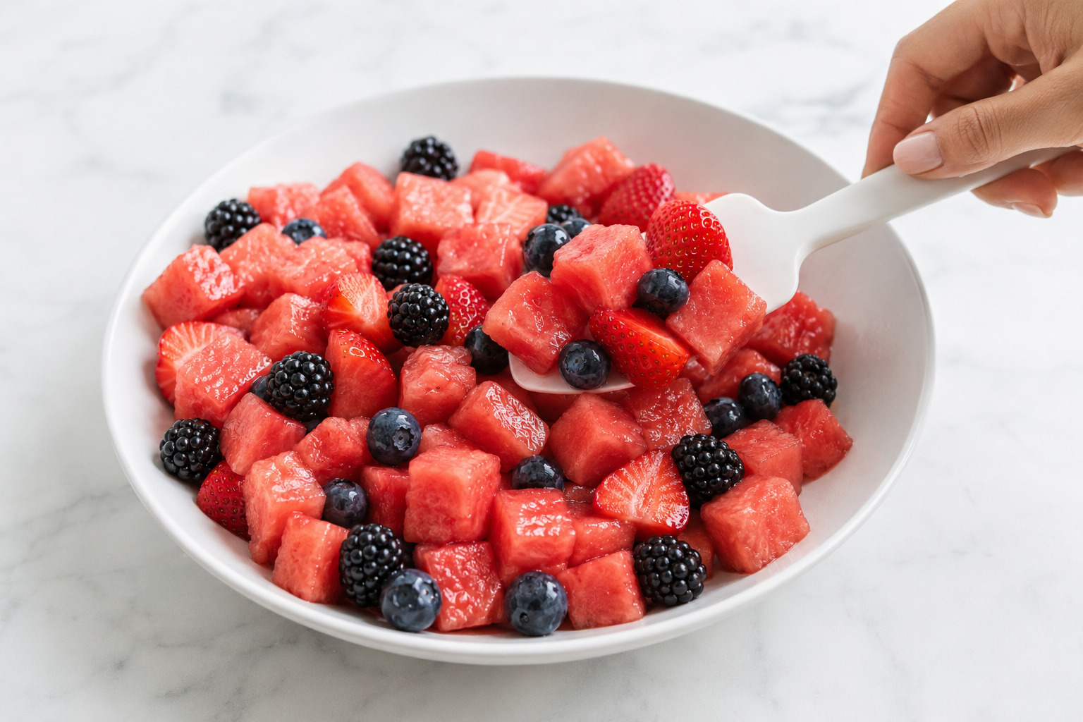 Watermelon fruit salad folded gently from the bottom to keep the berries intact