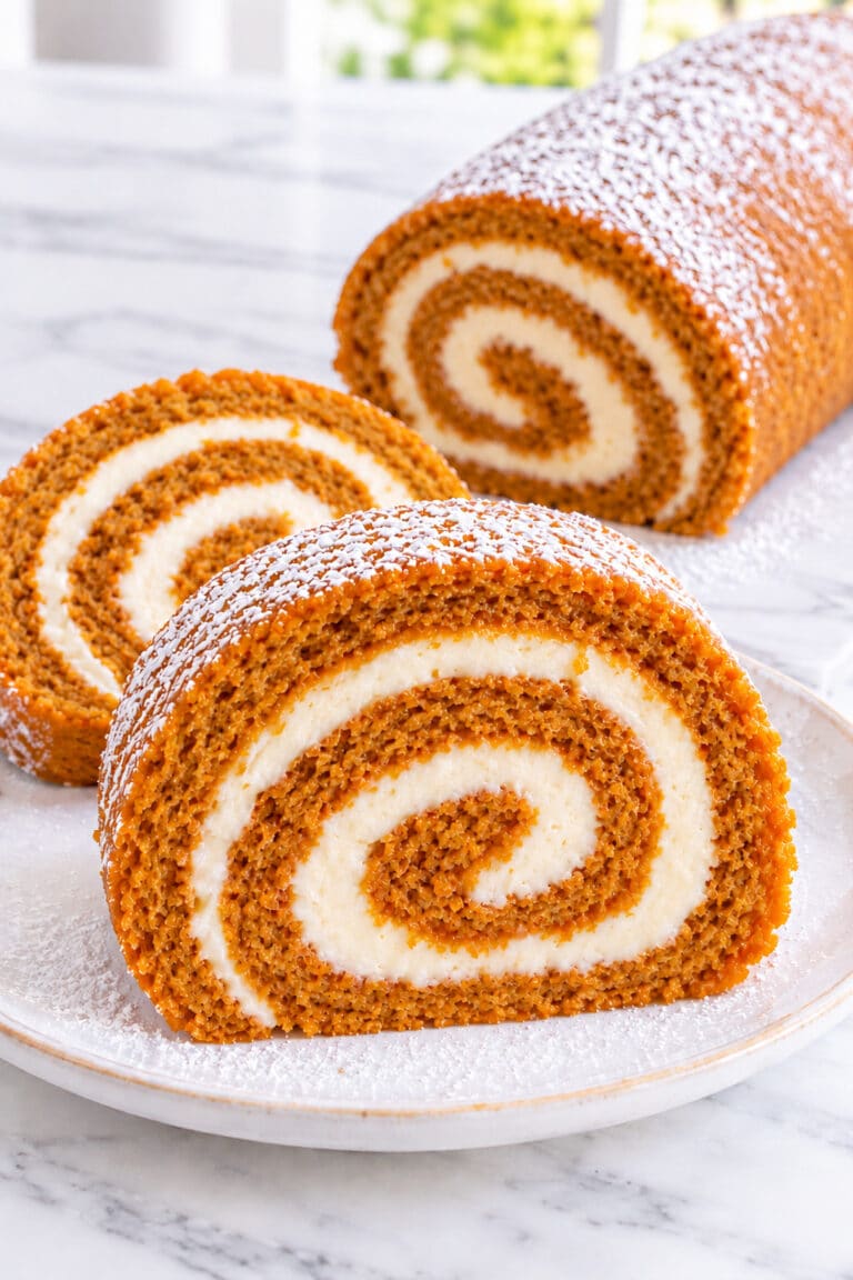 Pumpkin roll with cream cheese filling, a powdered whole roll, and three clear spiral slices